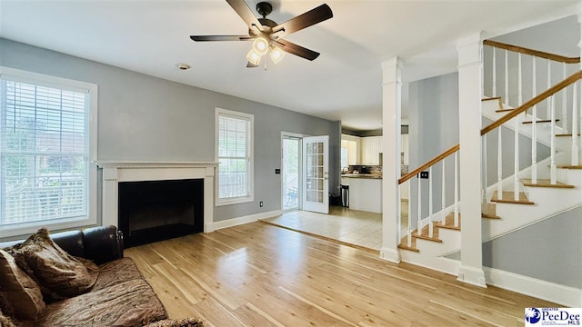 2423 Ben Hogan Cir, Florence, SC 29506 - unfurnished living room featuring ceiling fan, light wood-style floors, a fireplace, and stairway