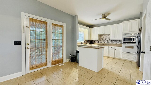 2423 Ben Hogan Cir, Florence, SC 29506 - kitchen with light tile patterned floors, white cabinetry, and tasteful backsplash