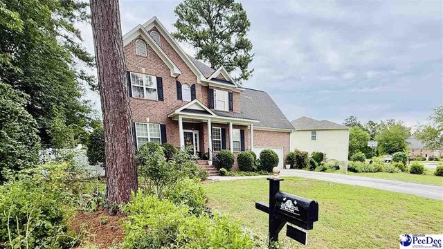 2423 Ben Hogan Cir, Florence, SC 29506 - traditional-style house featuring driveway, a garage, a front yard, and brick siding