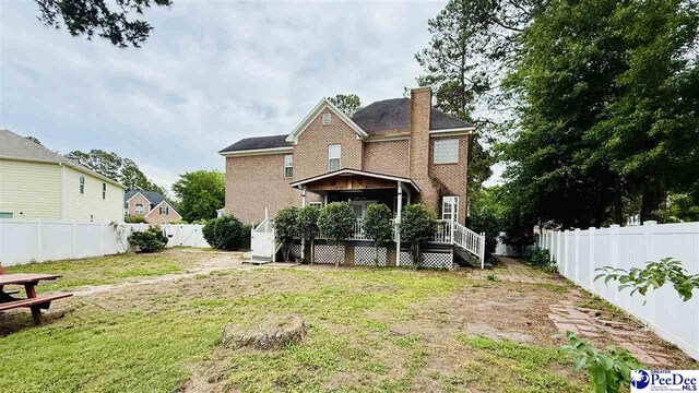 2423 Ben Hogan Cir, Florence, SC 29506 - rear view of house with a deck, a chimney, and brick siding