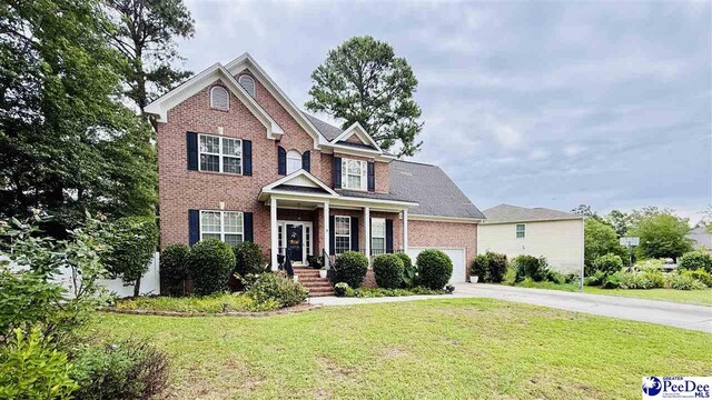 2423 Ben Hogan Cir, Florence, SC 29506 - traditional-style home featuring brick siding, driveway, a front yard, and a garage