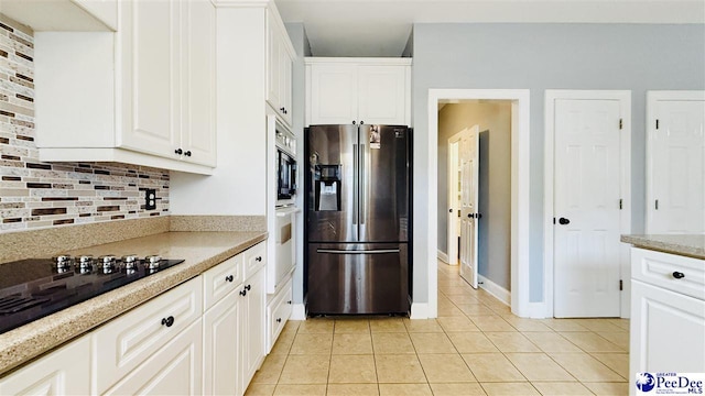 2423 Ben Hogan Cir, Florence, SC 29506 - kitchen with appliances with stainless steel finishes, light tile patterned flooring, backsplash, and white cabinetry