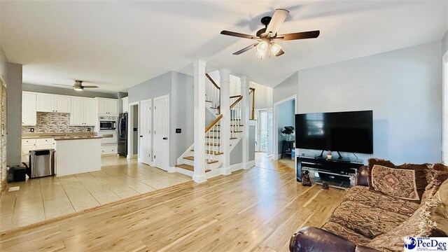 2423 Ben Hogan Cir, Florence, SC 29506 - living area featuring a ceiling fan, stairway, light wood-style floors, and vaulted ceiling