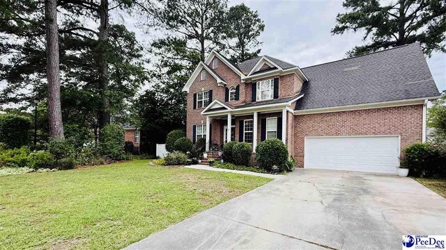 2423 Ben Hogan Cir, Florence, SC 29506 - view of front facade with brick siding, concrete driveway, a front lawn, covered porch, and an attached garage