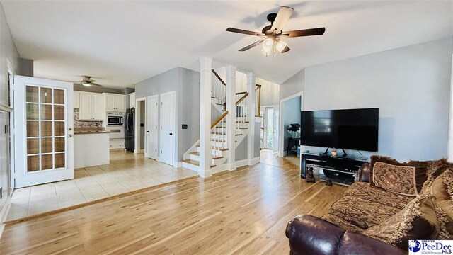 2423 Ben Hogan Cir, Florence, SC 29506 - living area featuring ceiling fan, stairway, light wood-style flooring, vaulted ceiling, and baseboards