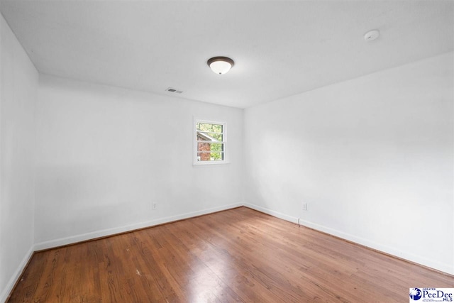 2206 W Piccadilly Dr, Florence, SC 29501 - spare room with wood finished floors, baseboards, and a smoke detector