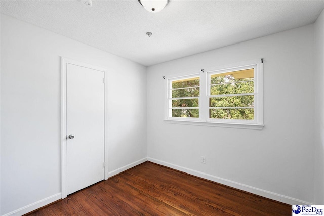 2206 W Piccadilly Dr, Florence, SC 29501 - unfurnished bedroom featuring dark wood-style flooring, baseboards, and a textured ceiling