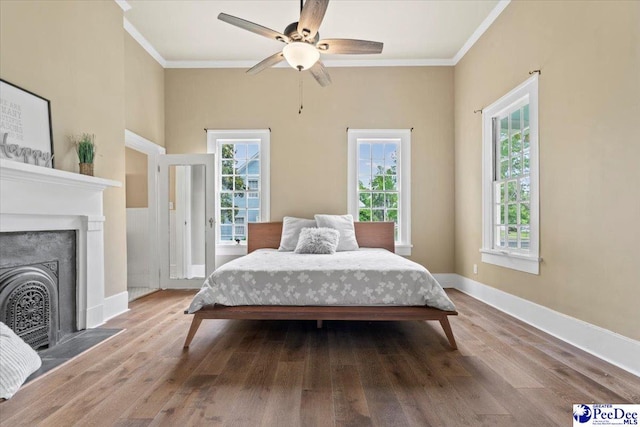 bedroom featuring hardwood / wood-style flooring, ceiling fan, and ornamental molding