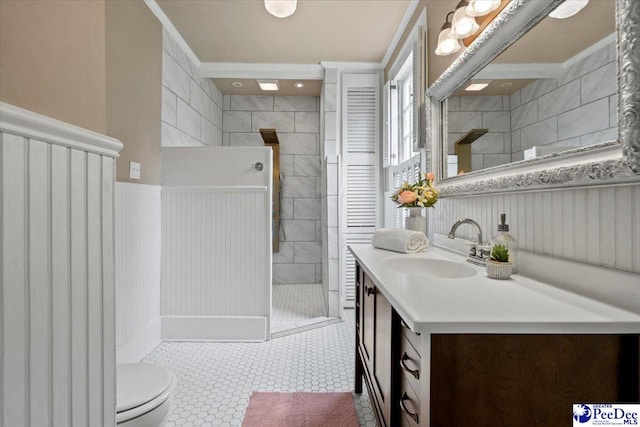 bathroom featuring vanity, toilet, and a tile shower