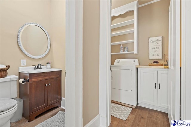 bathroom featuring vanity, washer / clothes dryer, hardwood / wood-style flooring, and toilet