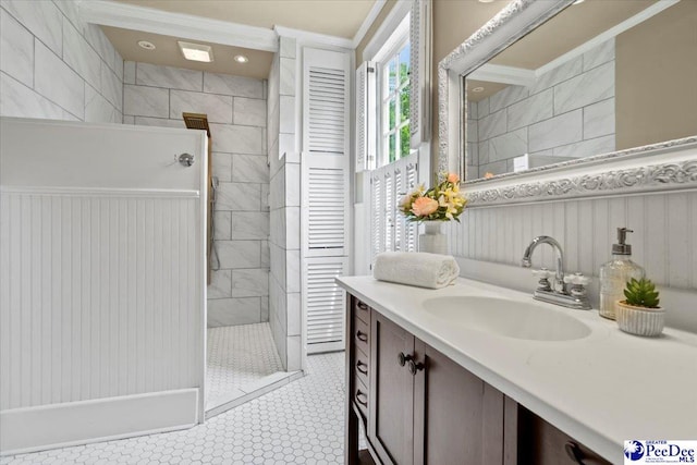 bathroom featuring a tile shower, vanity, and tile patterned flooring