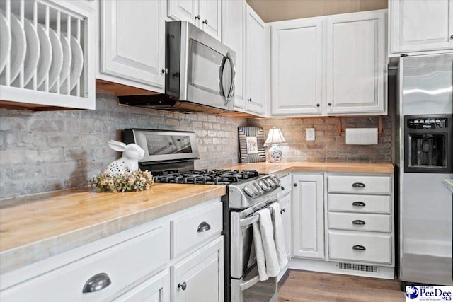 kitchen with tasteful backsplash, stainless steel appliances, and white cabinets