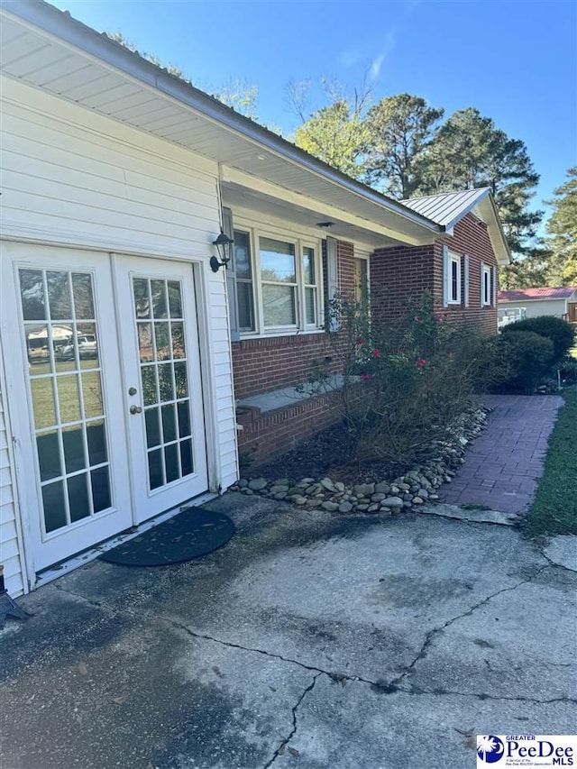 property entrance featuring a patio area and french doors