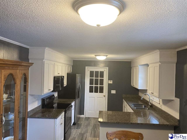 kitchen featuring sink, black appliances, kitchen peninsula, and white cabinets