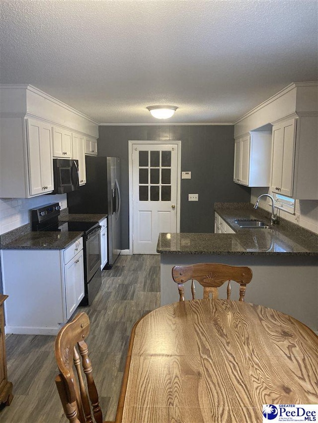 kitchen with sink, dark wood-type flooring, white cabinets, stainless steel electric range oven, and kitchen peninsula