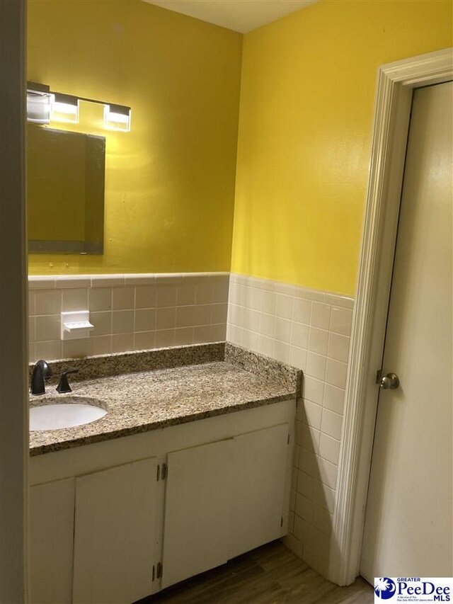 bathroom featuring tile walls, vanity, and hardwood / wood-style flooring