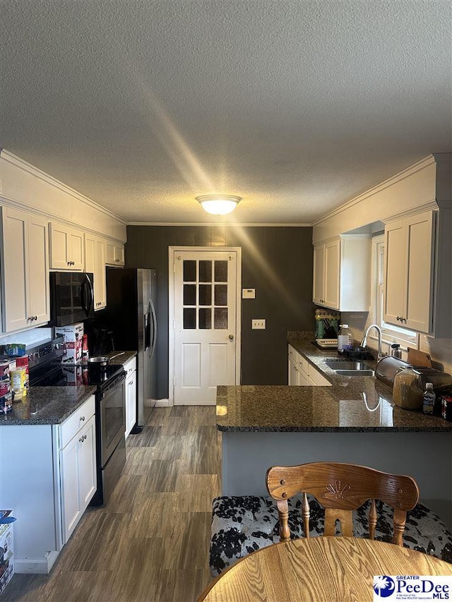 kitchen featuring white cabinetry, kitchen peninsula, dark stone counters, and electric stove