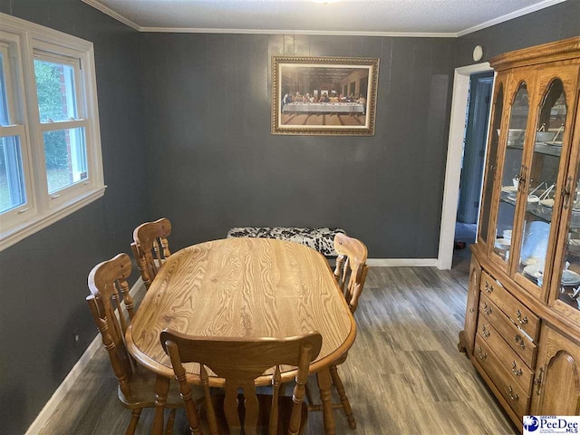 dining area featuring hardwood / wood-style flooring and ornamental molding