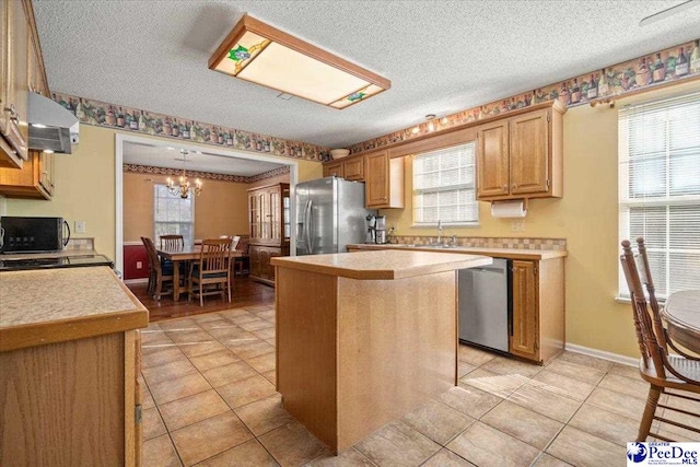 kitchen featuring stainless steel appliances, a center island, and plenty of natural light