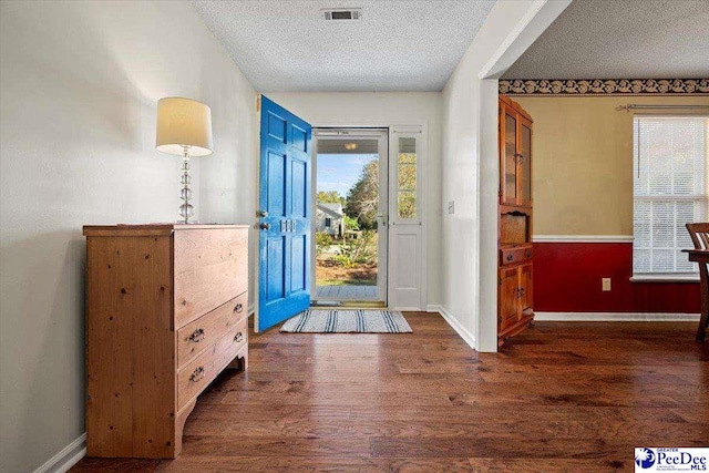 foyer featuring dark wood-type flooring and a textured ceiling