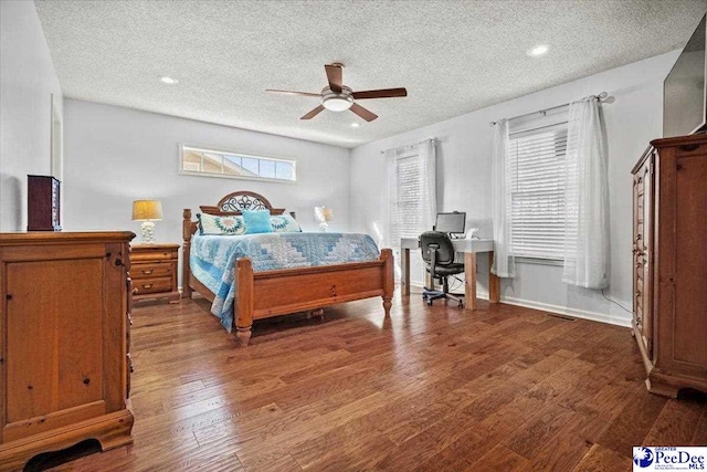 bedroom featuring ceiling fan, dark hardwood / wood-style flooring, and a textured ceiling