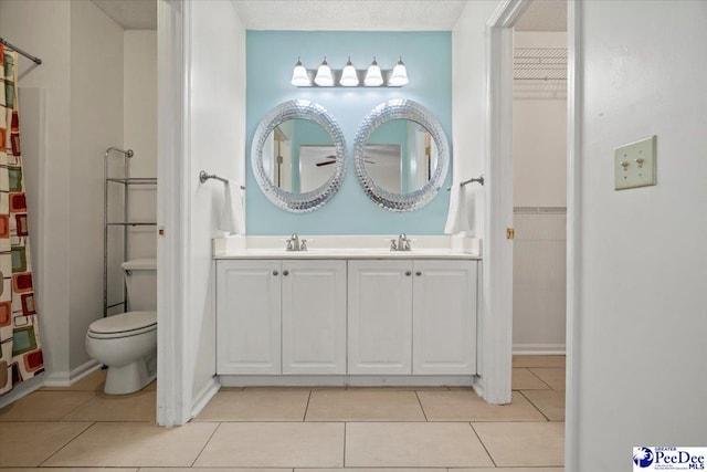 bathroom featuring tile patterned floors, toilet, vanity, and a textured ceiling