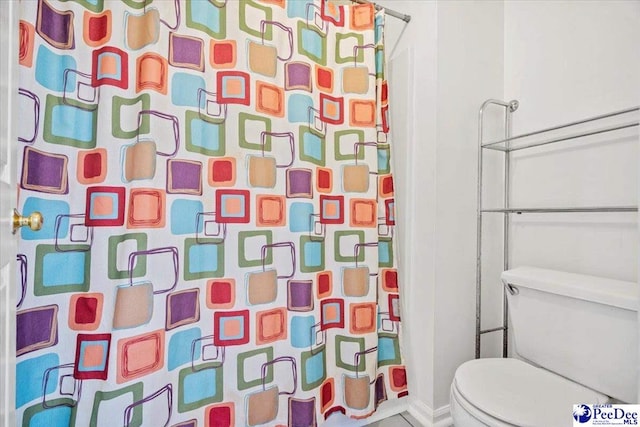 bathroom with toilet and curtained shower