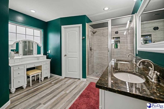 bathroom with wood-type flooring, vanity, and walk in shower