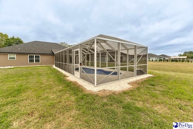 back of house featuring a lawn and glass enclosure