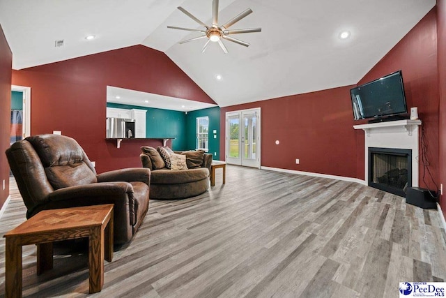 living room with high vaulted ceiling, light hardwood / wood-style floors, french doors, and ceiling fan