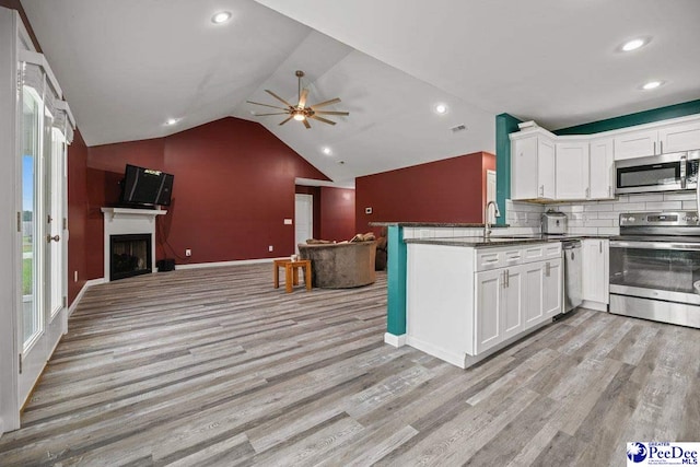 kitchen with white cabinetry, stainless steel appliances, kitchen peninsula, and light hardwood / wood-style flooring