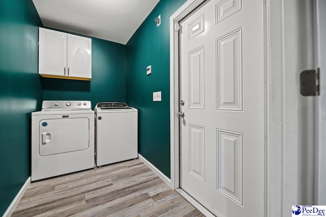 washroom featuring cabinets, separate washer and dryer, and light hardwood / wood-style floors