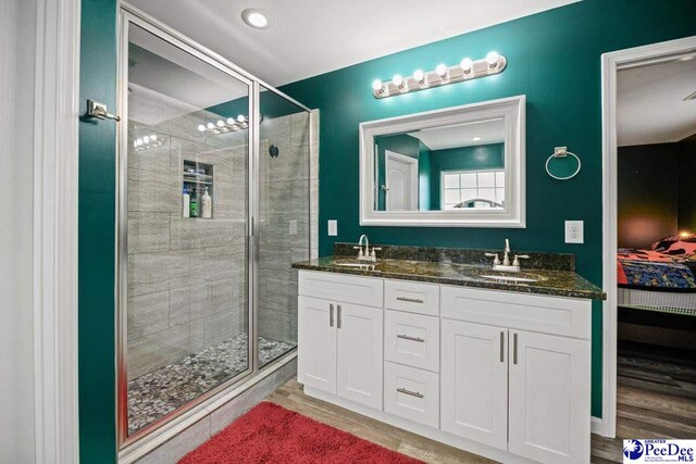 bathroom featuring vanity, wood-type flooring, and a shower with shower door