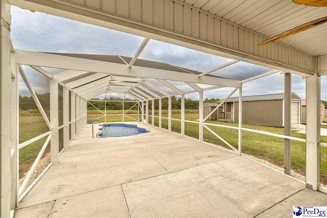 view of patio featuring glass enclosure and a storage unit