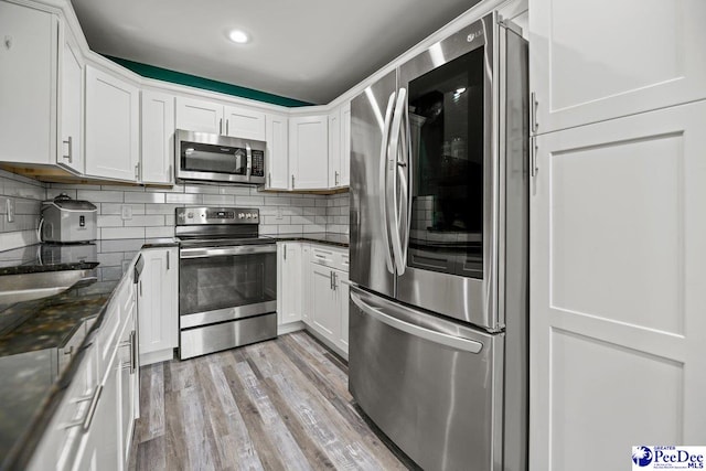 kitchen with white cabinetry, light hardwood / wood-style floors, and appliances with stainless steel finishes