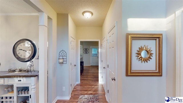 hallway featuring wood-type flooring and a textured ceiling