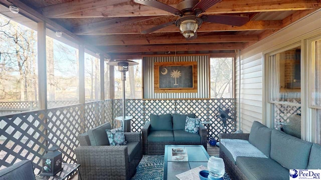 sunroom / solarium with beamed ceiling, a healthy amount of sunlight, and ceiling fan