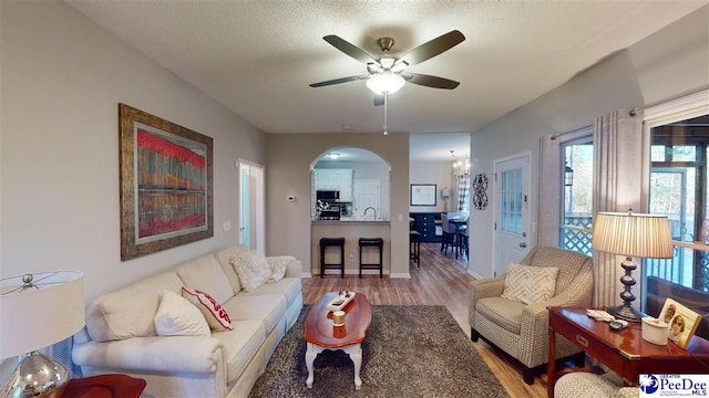 living room featuring hardwood / wood-style floors, a textured ceiling, sink, and ceiling fan