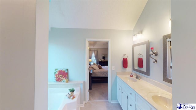 bathroom with a bathing tub, lofted ceiling, vanity, and tile patterned floors