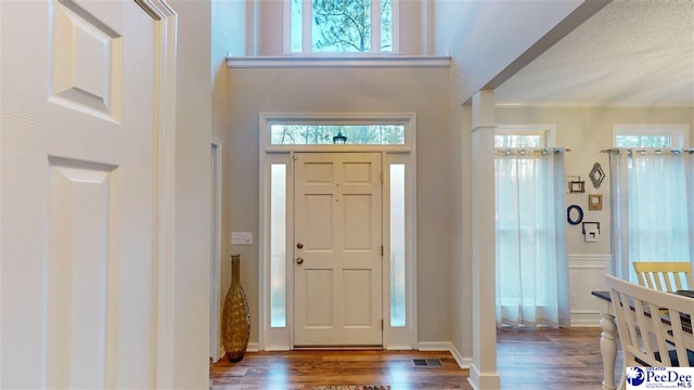 entrance foyer with a high ceiling, crown molding, and dark hardwood / wood-style floors