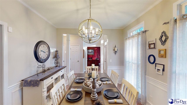 dining area with crown molding, hardwood / wood-style floors, and a notable chandelier