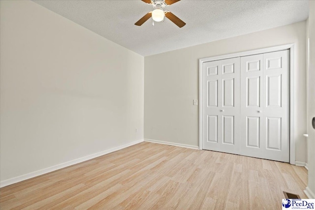 1763 Lipscomb Rd, Mullins, SC 29574 - unfurnished bedroom with light wood finished floors, baseboards, a closet, a textured ceiling, and ceiling fan