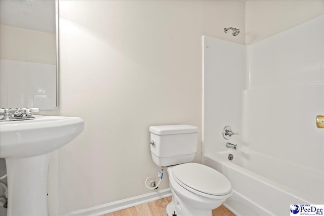 1763 Lipscomb Rd, Mullins, SC 29574 - bathroom with toilet, wood finished floors, baseboards,  shower combination, and a sink