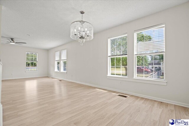 1763 Lipscomb Rd, Mullins, SC 29574 - empty room with light wood-type flooring, a textured ceiling, a chandelier, ceiling fan, and baseboards