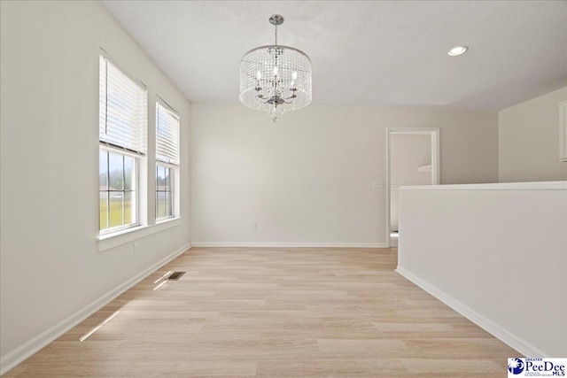 1763 Lipscomb Rd, Mullins, SC 29574 - empty room with a chandelier, a textured ceiling, baseboards, light wood-type flooring, and recessed lighting
