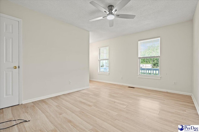 1763 Lipscomb Rd, Mullins, SC 29574 - unfurnished room featuring plenty of natural light, a textured ceiling, light wood-style floors, ceiling fan, and baseboards