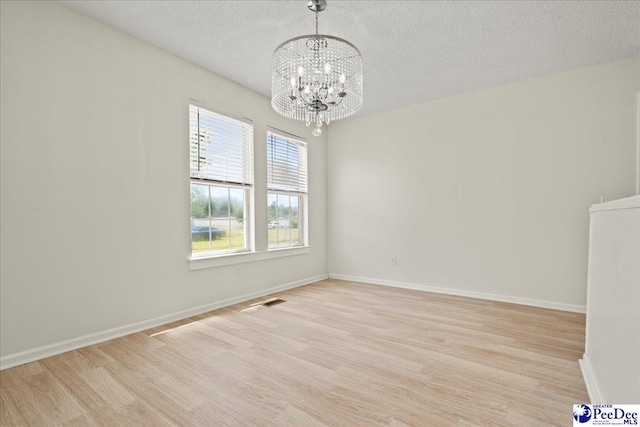 1763 Lipscomb Rd, Mullins, SC 29574 - spare room featuring a chandelier, light wood-type flooring, a textured ceiling, and baseboards