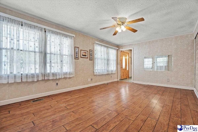 2810 Boxwood Ave, Florence, SC 29501 - spare room featuring a textured ceiling, wood-type flooring, a ceiling fan, plenty of natural light, and baseboards