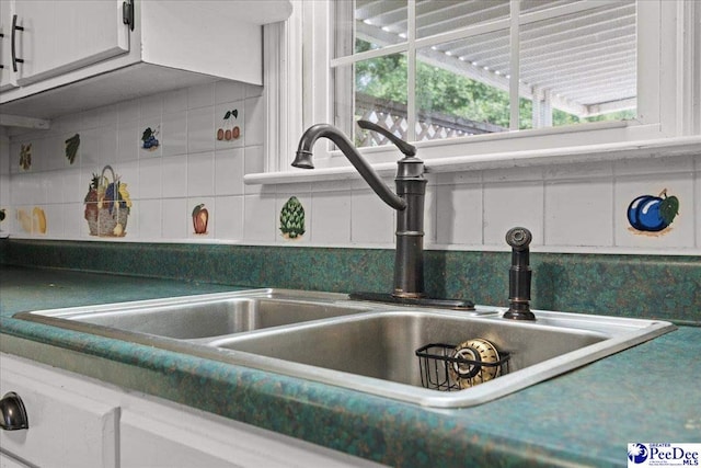 2810 Boxwood Ave, Florence, SC 29501 - kitchen view of a sink, decorative backsplash, white cabinets, and dark countertops