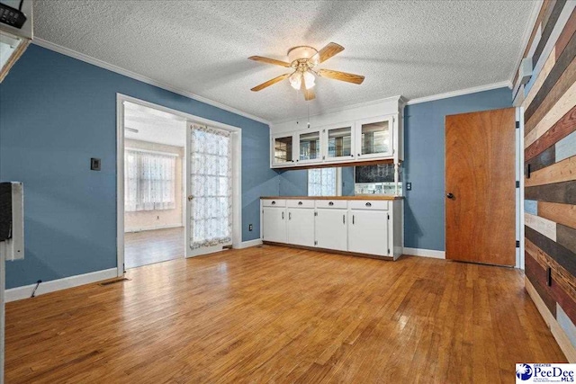 2810 Boxwood Ave, Florence, SC 29501 - kitchen with ornamental molding, light wood-style floors, white cabinetry, ceiling fan, and a textured ceiling